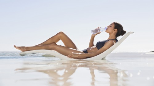 woman-at-beach-drinking-water